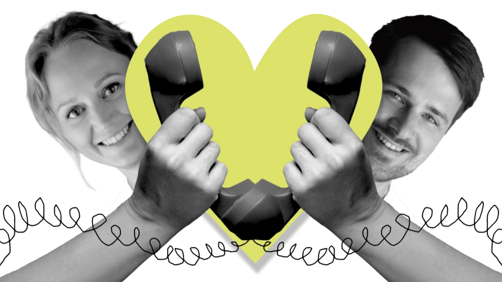 Helen and Jaanus holding a yellow heart-shaped telephone receiver between them